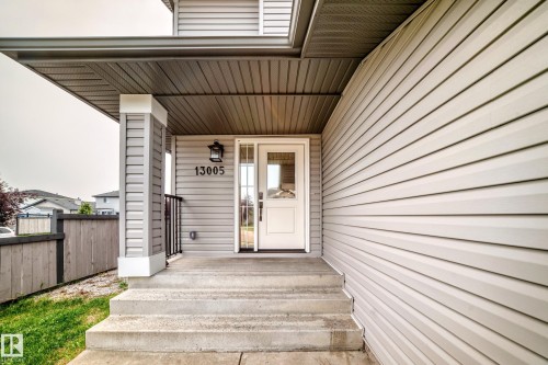 Light-colored siding exterior featuring a covered entryway with concrete steps - 13005 162A Avenue Nw, Edmonton, AB - Outdoor With Exterior