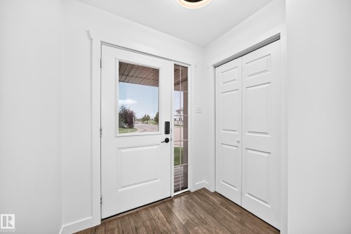 Entryway featuring a white paneled door with a rectangular glass insert, sidelight, and wood-finish flooring - 13005 162A Avenue Nw, Edmonton, AB - Indoor Photo Showing Other Room
