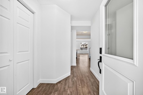 Entryway featuring wood-finish flooring, white baseboards, and a paneled entry door with an integrated glass panel and black hardware - 13005 162A Avenue Nw, Edmonton, AB - Indoor Photo Showing Other Room