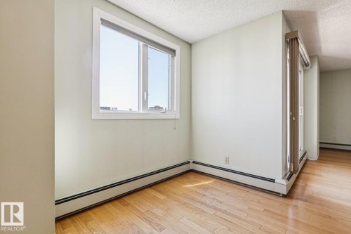 Wood-finish flooring, white window frame, and baseboard heating - #905 9929 113 St Nw, Edmonton, AB 