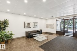 Tiled flooring with recessed lighting and a mailroom wall - 