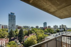Balcony with black metal railing overlooking a cityscape with mature trees and diverse architectural styles - 