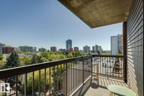Balcony with concrete flooring, metal railings, and a wood-paneled exterior wall - #905 9929 113 St Nw, Edmonton, AB 