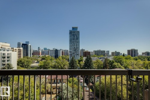Urban skyline backdrop with a variety of architectural styles, expansive green tree canopy, and a black metal railing - #905 9929 113 St Nw, Edmonton, AB 