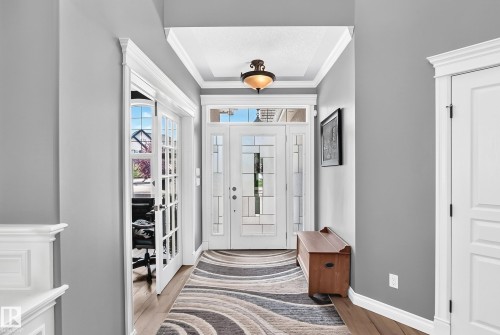 Entryway featuring a coffered ceiling, engineering wood flooring, and a white paneled door with sidelights - 417 Caldwell Place Nw, Edmonton, AB 