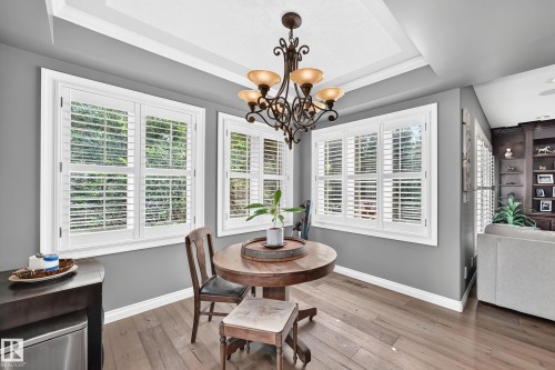 Recessed ceiling with crown molding, decorative chandelier, white plantation shutters, built-in shelving - 417 Caldwell Place Nw, Edmonton, AB 