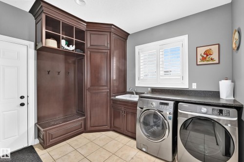 Built-in cabinetry with bench seating and shelving, undermount sink, countertop workspace, and tile flooring - 417 Caldwell Place Nw, Edmonton, AB 