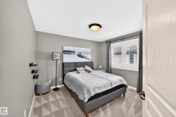 Neutral gray walls, wall-to-wall patterned carpeting, recessed window with plantation shutters, and a ceiling-mounted light fixture - 