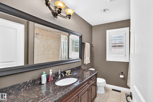 Vanity with stone countertop, undermount sink, and dark wood-finish cabinetry - 417 Caldwell Place Nw, Edmonton, AB 