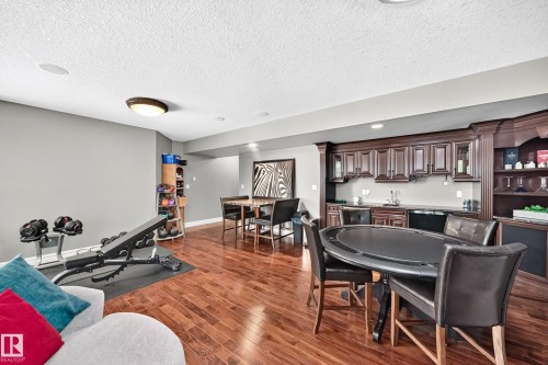 recessed lighting, built-in wet bar with dark wood cabinetry, integrated shelving, and a sink - 417 Caldwell Place Nw, Edmonton, AB 