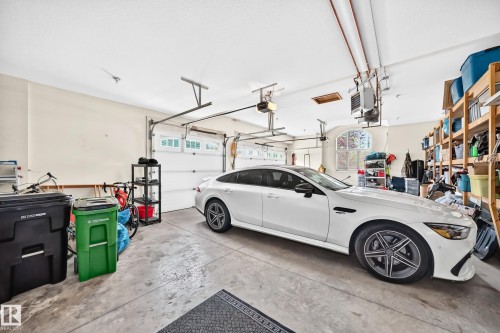 3 car garage with concrete flooring, two overhead garage doors, and built-in shelving - 417 Caldwell Place Nw, Edmonton, AB 