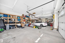Spacious garage featuring concrete flooring and extensive built-in wooden shelving for ample storage - 