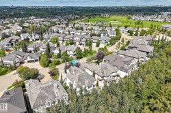 Aerial perspective of a developed residential area with mature trees and a manicured green space - 