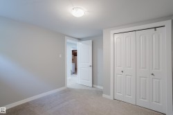 Recessed lighting fixture, light gray wall paint, light-colored carpet, white bi-fold closet doors, and white interior door - 