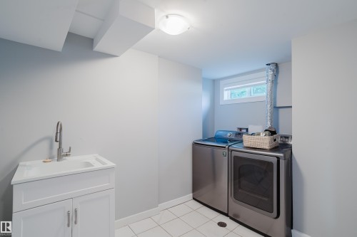 White tile flooring, utility sink with white cabinetry, ceiling-mounted light fixture, and window - 4708 106 Avenue Nw, Edmonton, AB 