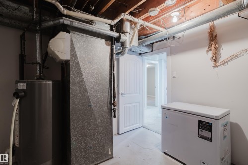Exposed wood beam ceiling, white paneled interior door, and a water heater - 4708 106 Avenue Nw, Edmonton, AB 
