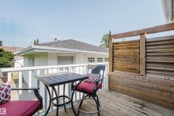 Deck with wood plank flooring and a slatted wood privacy wall - 