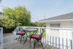 Wood-finish deck with white railings and an outdoor stairwell - 