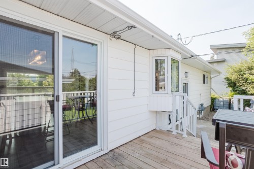 Exterior deck with wood-finish flooring, white siding, and a bay window - 4708 106 Avenue Nw, Edmonton, AB 