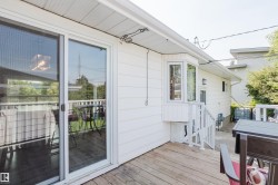 Exterior deck with wood-finish flooring, white siding, and a bay window - 