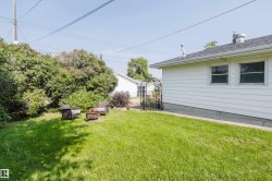 Expansive green lawn with mature perimeter shrubbery and a white siding exterior - 