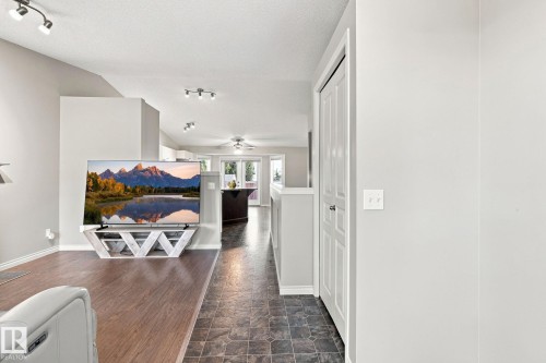 Wood-finish flooring, track lighting, and a white bi-fold door - 30 Belfry Fairway Crescent, Stony Plain, AB 