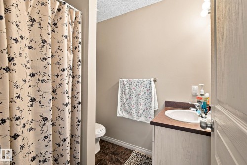 Vanity with integrated sink and storage, tile flooring, and wall-mounted lighting - 30 Belfry Fairway Crescent, Stony Plain, AB 