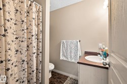 Vanity with integrated sink and storage, tile flooring, and wall-mounted lighting - 