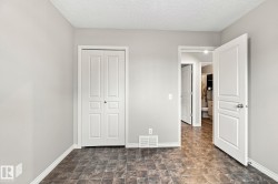 Textured ceiling, neutral wall paint, white trim, bifold closet doors, and wood-finish flooring - 