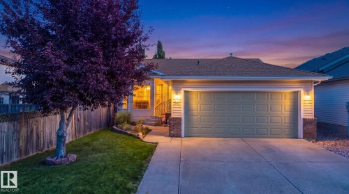 Two-car garage with paneling, brick veneer accents, and sconce lighting - 30 Belfry Fairway Crescent, Stony Plain, AB 