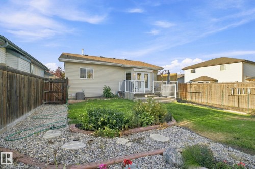 Expansive backyard featuring a multi-level deck, direct access to the interior, a privacy fence, and a rock garden with stepping stones - 30 Belfry Fairway Crescent, Stony Plain, AB 