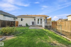 Expansive green lawn with a wooden privacy fence - 