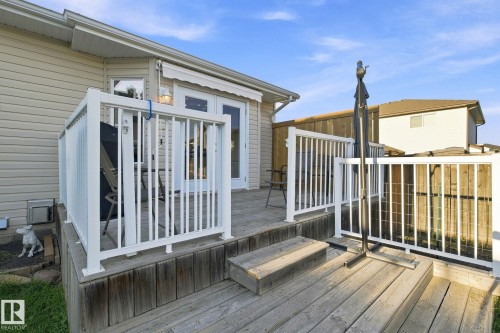 Wooden deck with white railings, featuring double glass doors and an awning - 30 Belfry Fairway Crescent, Stony Plain, AB 