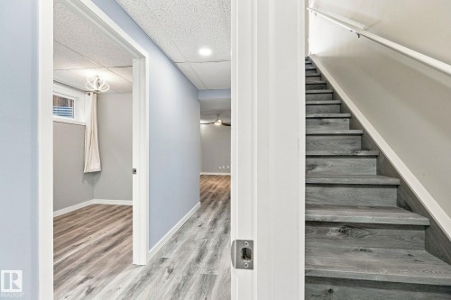 Wood-finish stairs with white handrail, recessed lighting, and wood-finish flooring throughout - 30 Belfry Fairway Crescent, Stony Plain, AB 