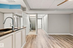 Wood-finish flooring, recessed lighting, and a utility sink with a chrome faucet - 