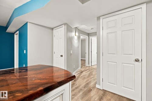 Wood-finish flooring, white paneled doors, and a built-in countertop with a polished surface - 30 Belfry Fairway Crescent, Stony Plain, AB 