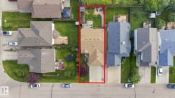 Aerial perspective showcasing the property's footprint, front driveway, and rear yard - 