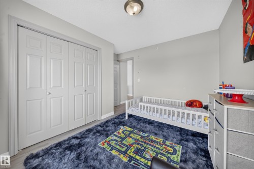 Bifold closet doors, light wood-finish flooring, and a flush mount ceiling fixture - #419 4407 23 St Nw, Edmonton, AB 