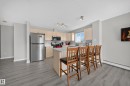 Kitchen featuring light wood-finish cabinetry, stainless steel appliances, a light-toned countertop, and wood-finish flooring - #419 4407 23 St Nw, Edmonton, AB 