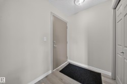 Entryway featuring a solid core door, wood-finish flooring, and bi-fold closet doors - 