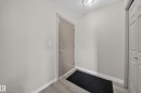 Entryway featuring a solid core door, wood-finish flooring, and bi-fold closet doors - #419 4407 23 St Nw, Edmonton, AB 