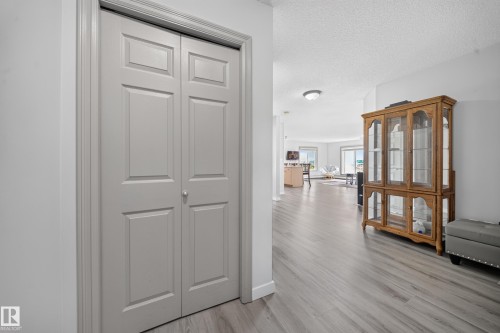 Recessed panel bifold doors, light gray walls, and wood-finish flooring - #419 4407 23 St Nw, Edmonton, AB 