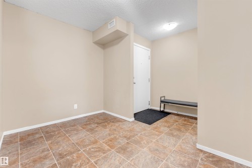 Entryway featuring large format floor tiles, neutral wall tones, and a flush mount ceiling light - #225 111 Watt Cm Sw, Edmonton, AB 