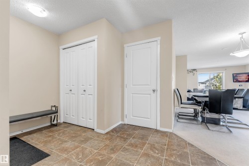 Entryway featuring tile flooring, white bi-fold closet doors, and light neutral wall tones - #225 111 Watt Cm Sw, Edmonton, AB 