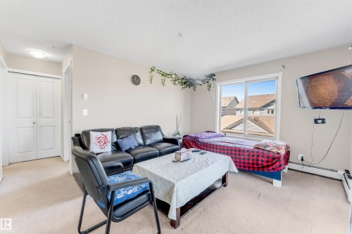 Carpeted flooring extending throughout, neutral wall paint, and a double-panel closet door - #225 111 Watt Cm Sw, Edmonton, AB 