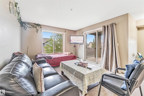 Sliding glass door leading to a balcony, a window, and light-toned walls - #225 111 Watt Cm Sw, Edmonton, AB 
