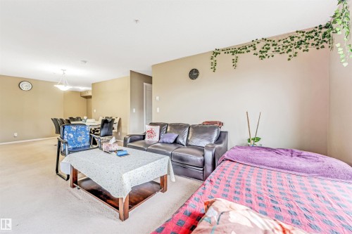 Carpeted living area with neutral wall tones and recessed lighting - #225 111 Watt Cm Sw, Edmonton, AB 