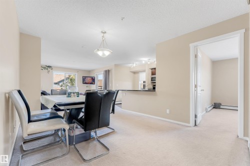 Recessed lighting, pass-through counter, sliding glass door, neutral carpeting, and a ceiling light fixture - #225 111 Watt Cm Sw, Edmonton, AB 