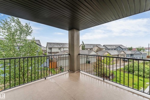 Private balcony with a concrete floor, black metal railing, and a slatted overhang - #225 111 Watt Cm Sw, Edmonton, AB 