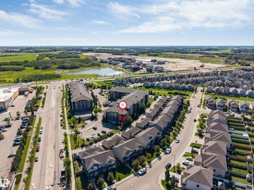 Residential buildings with dark roofs, surrounded by paved roads and green spaces - #225 111 Watt Cm Sw, Edmonton, AB 
